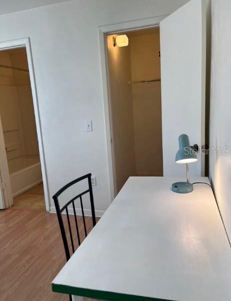 A desk with a lamp sits in a room with wood-look flooring and two doorways — 3800 SW 20TH AVENUE UNIT 306, GAINESVILLE, FL