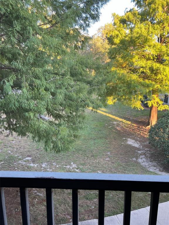 A view of a grassy yard with trees from a balcony with a black railing — 3800 SW 20TH AVENUE UNIT 306, GAINESVILLE, FL