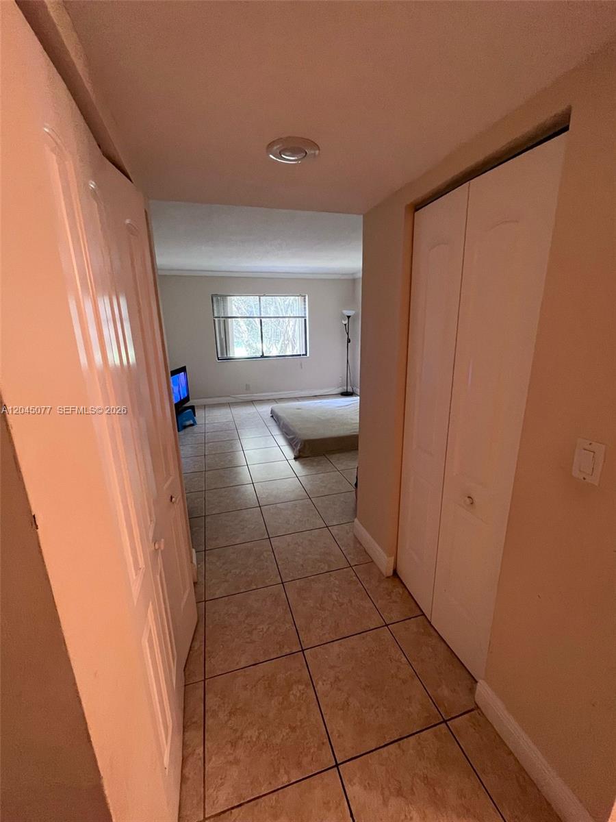 A kitchen features stainless steel appliances, wood cabinetry, and a tiled backsplash — 197 Lakeview Dr # 105, Weston FL 33326, WESTON, FL