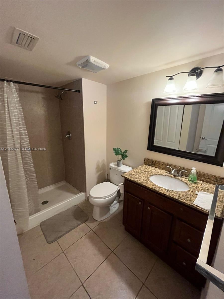 A kitchen features wood cabinets, stainless steel appliances, and a black countertop peninsula — 197 Lakeview Dr # 105, Weston FL 33326, WESTON, FL