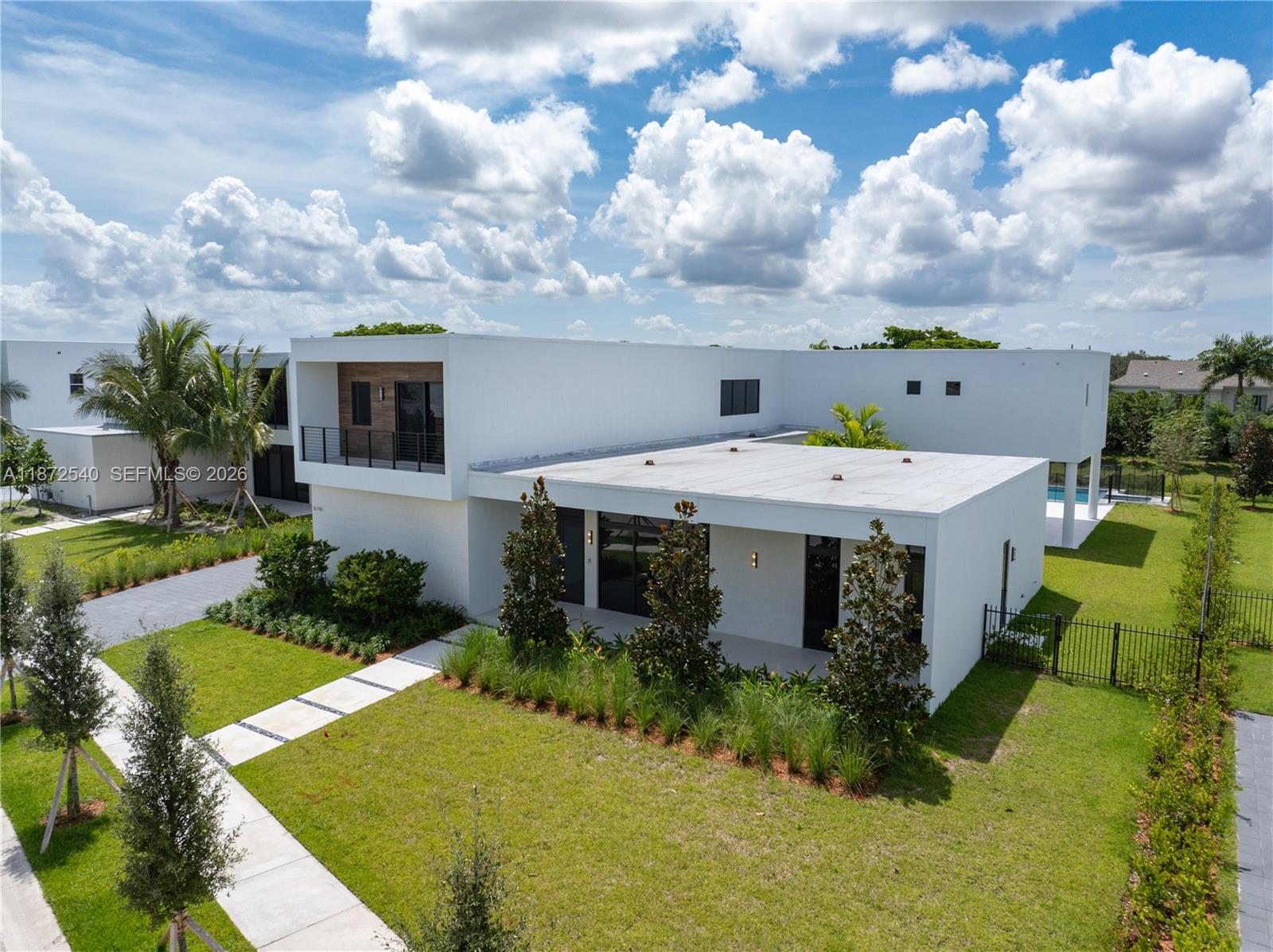 An aerial view shows a modern white two-story house with a flat roof and landscaping — 16740 N Botaniko Dr N, Weston FL 33326, WESTON, FL