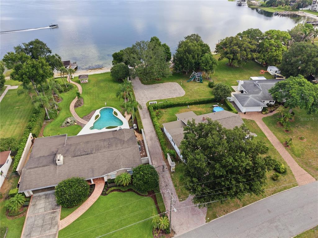 An aerial view shows two houses with pools and landscaping on a lakefront property — 2817 FLOWERTREE ROAD, ORLANDO, FL