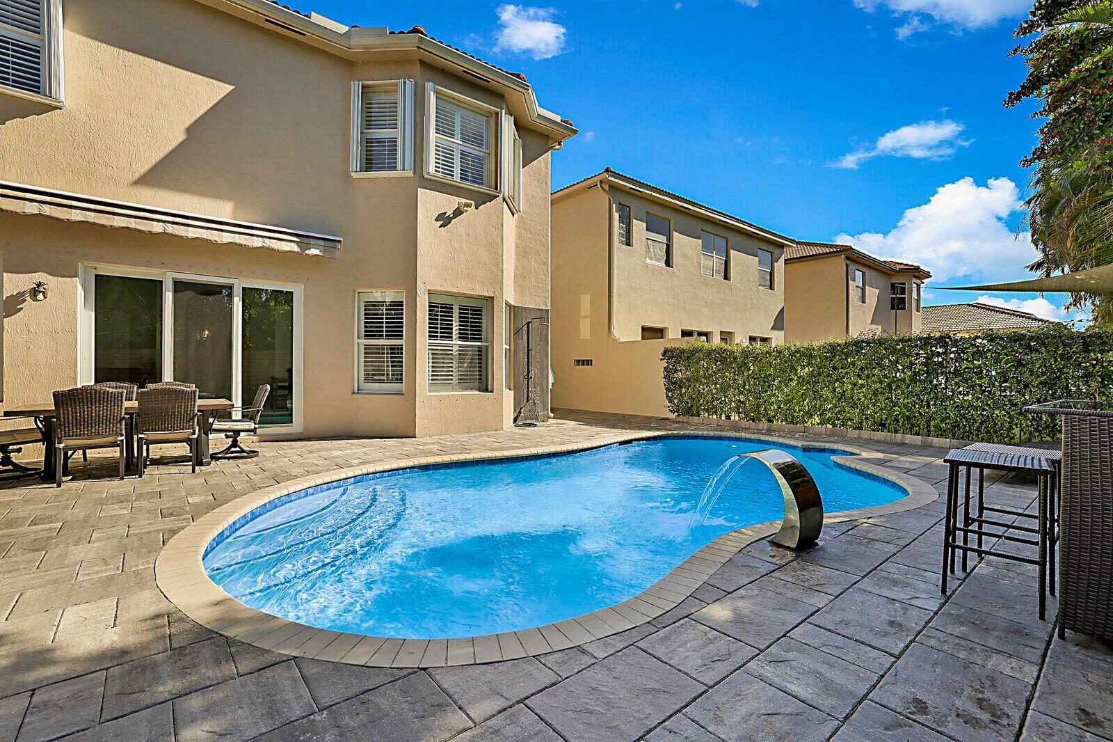 A two-story suburban house features a tiled roof, a white garage door, and palm trees — 7167 Ivy Crossing Lane, Boynton Beach FL 33436, BOYNTON BEACH, FL