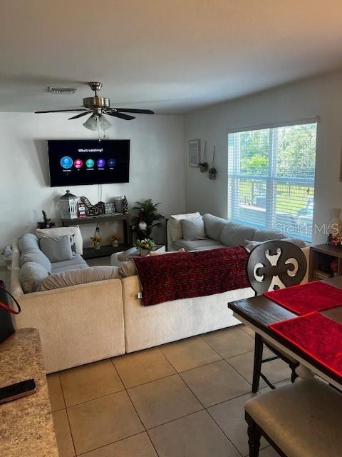 A living room features a large sectional sofa, a wall-mounted television, and tile flooring — 3449 ACAPULCO CIRCLE, CAPE CORAL, FL