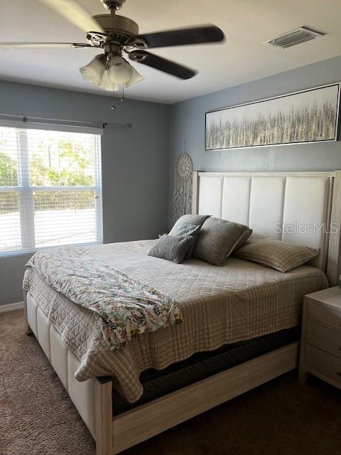 A bedroom features a large bed with a tufted headboard, a ceiling fan, and wall art — 3449 ACAPULCO CIRCLE, CAPE CORAL, FL