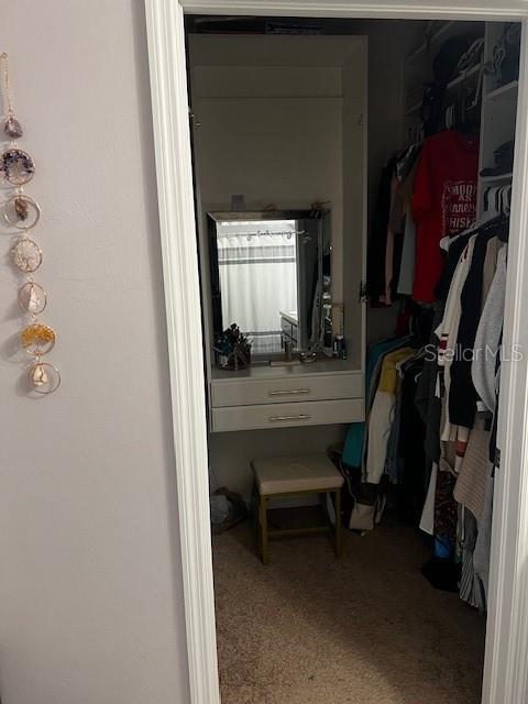 A walk-in closet features a built-in vanity with a mirror, two drawers, and a stool — 3449 ACAPULCO CIRCLE, CAPE CORAL, FL