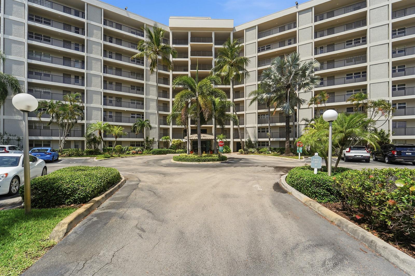 A multi-story apartment building with balconies and palm trees in a circular driveway — 2681 S Course Drive # 808, Pompano Beach FL 33069, POMPANO BEACH, FL
