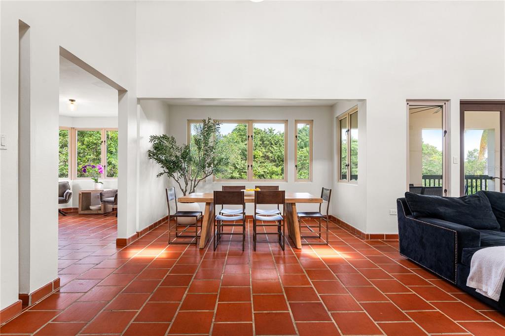 A dining area with a wooden table and chairs sits on terracotta tile flooring — 86 LAKESIDE VILLAS UNIT G2, VEGA ALTA, PR