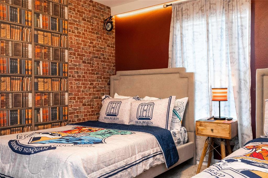 A bedroom features Harry Potter-themed decor, a brick accent wall, and two beds — 4383 SCENE LANE, KISSIMMEE, FL