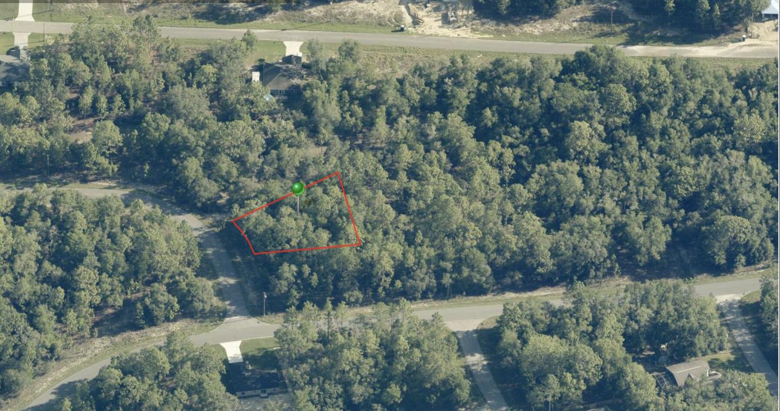 An aerial view shows a vacant, wooded residential lot outlined in red — 1915 W Shellbark Drive, FL 34434, FL