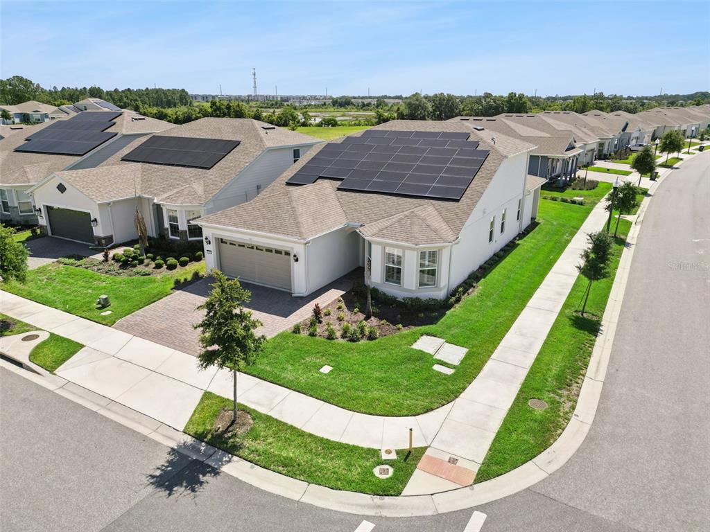 An aerial view shows a suburban house with solar panels on its roof — 13361 SUNNY RETREAT LANE, WINTER GARDEN, FL