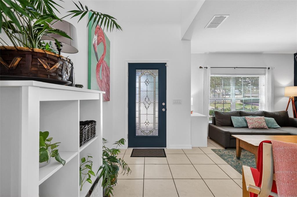 An entryway with a blue front door leads into a living room with tiled floors — 34040 ALAMEDA DRIVE, SORRENTO, FL
