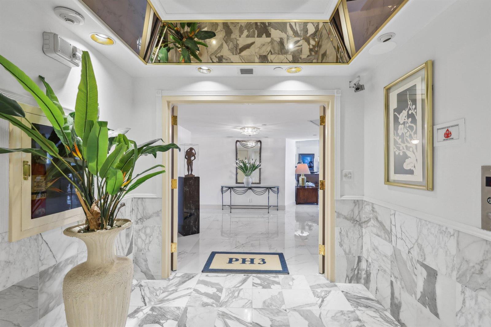 An entryway features double doors, marble flooring, a large potted plant, and a mirrored ceiling — 4001 N Ocean Boulevard, Boca Raton FL 33431, BOCA RATON, FL