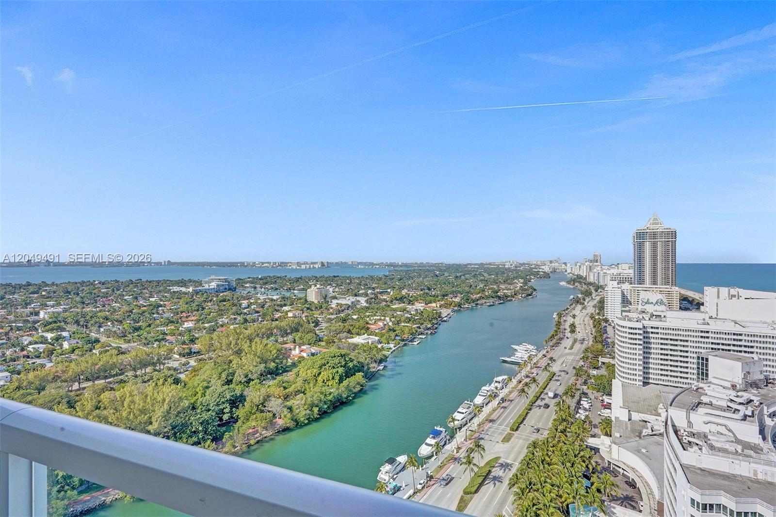 An elevated view shows a waterway, coastal buildings, and a road with palm trees — 4401 Collins Ave # 2915, Miami Beach FL 33140, MIAMI BEACH, FL