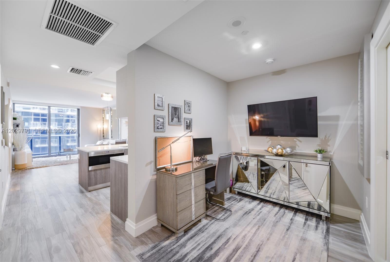A home office area features a desk, a mirrored console, and a wall-mounted television — 801 S Miami Ave # 3706, Miami FL 33130, MIAMI, FL