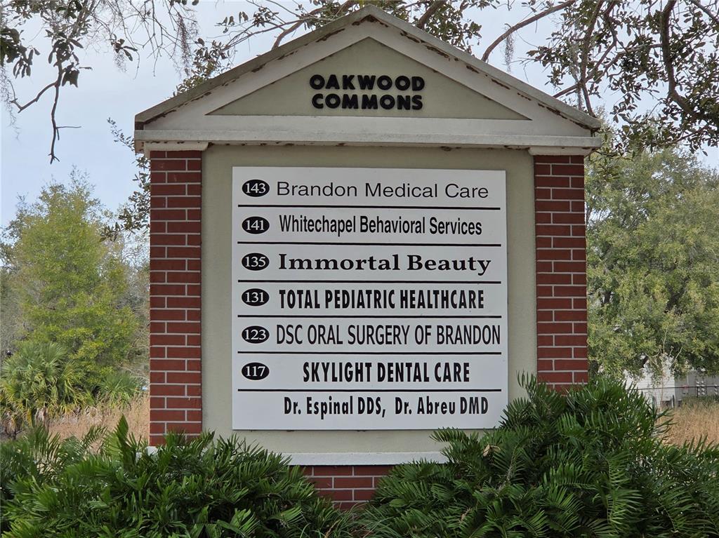 A single-story brick commercial building features a white-columned entrance and a paved parking lot — 141 N OAKWOOD AVENUE, BRANDON, FL