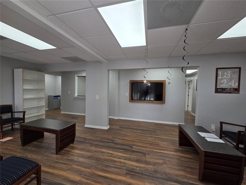 A waiting room features wood-look flooring, four chairs, a coffee table, and a bookshelf — 141 N OAKWOOD AVENUE, BRANDON, FL
