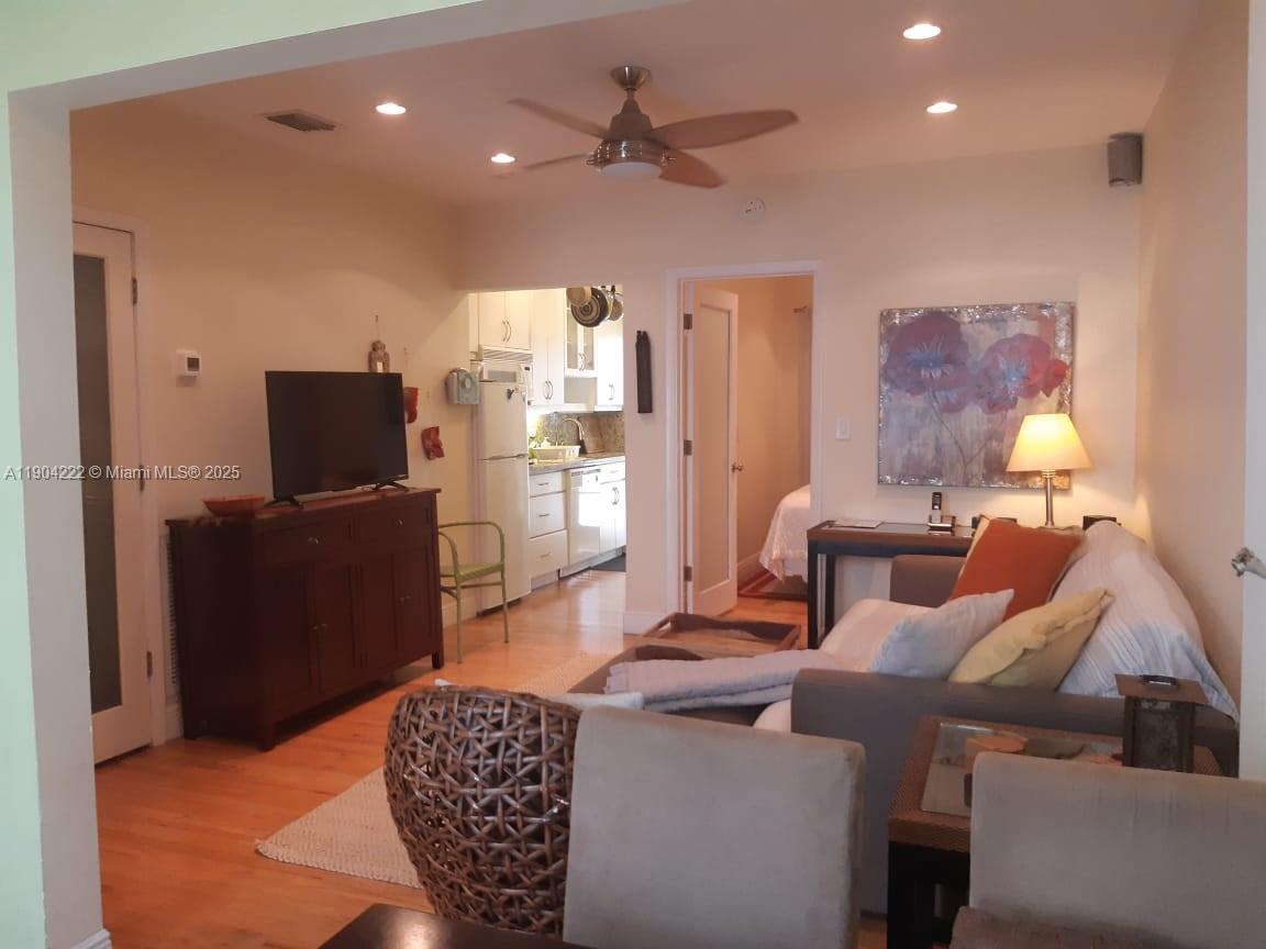 This living room features a ceiling fan, hardwood floors, and an open kitchen view — 744 Lenox Ave # 3, Miami Beach FL 33139, MIAMI BEACH, FL