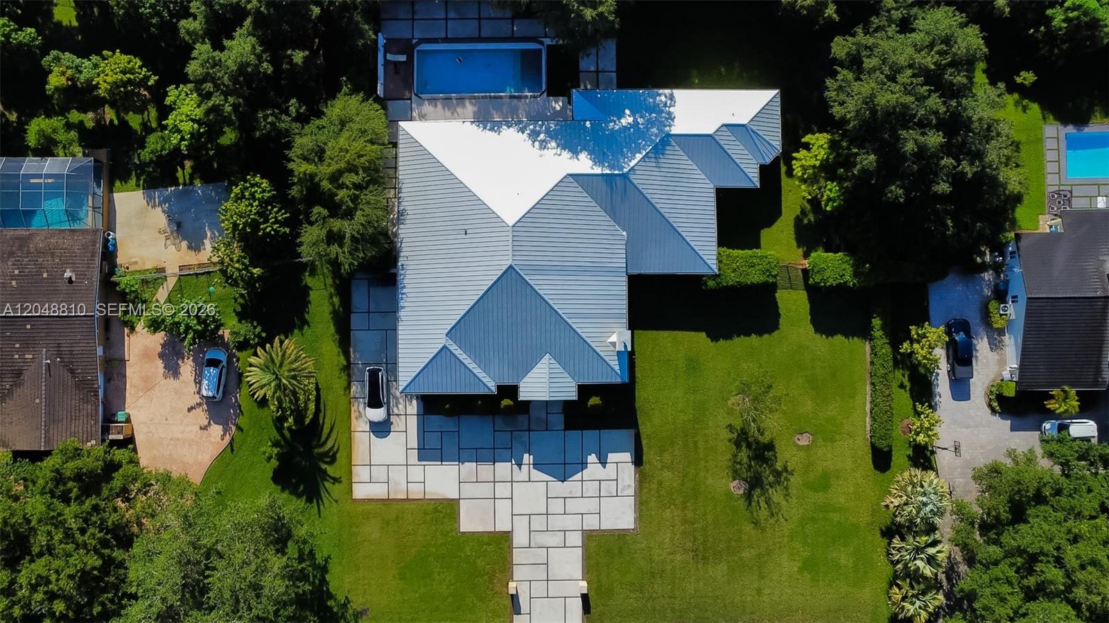 An aerial view shows a house with a metal roof, a pool, and paved walkways — 9805 sw 90th ave, Kendall FL 33176, KENDALL, FL