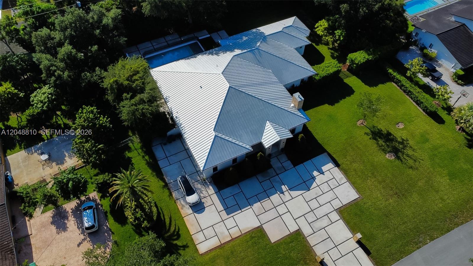 An aerial view shows a house with a metal roof, a pool, and a paved driveway — 9805 sw 90th ave, Kendall FL 33176, KENDALL, FL