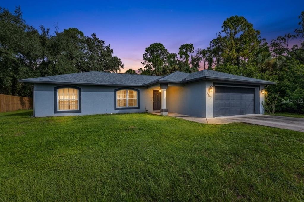 A single-story house with a gray exterior, a two-car garage, and a grassy front yard — 3237 CLEARFIELD STREET, NORTH PORT, FL