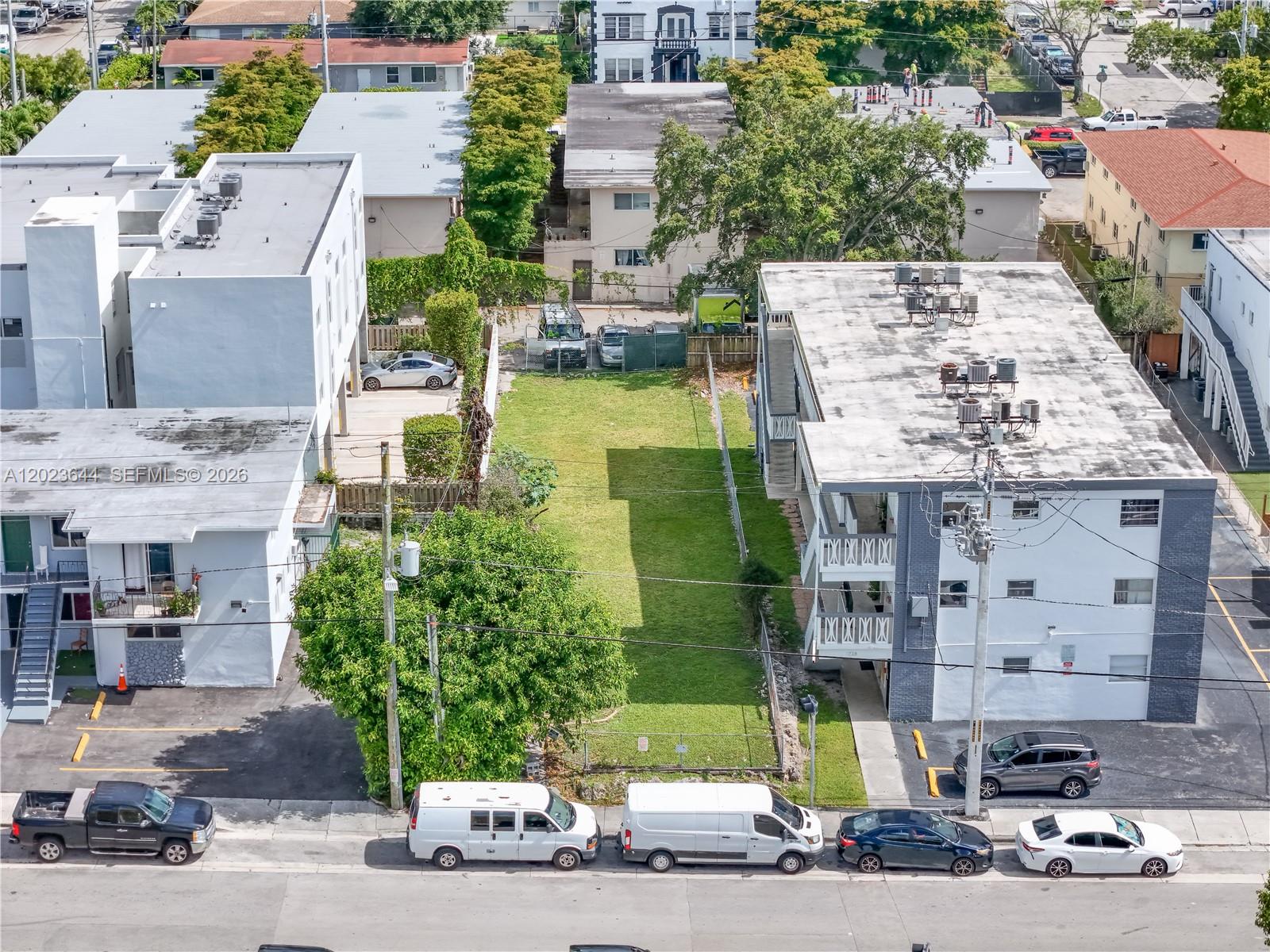 An aerial view shows a vacant grassy lot situated between two multi-story apartment buildings — 718 SW 4th St, Miami FL 33130, MIAMI, FL