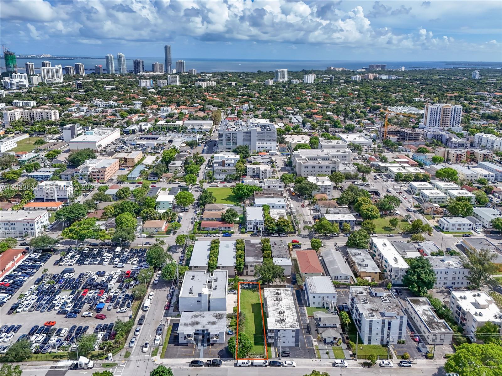 An aerial view shows a vacant rectangular lot outlined in orange between two apartment buildings — 718 SW 4th St, Miami FL 33130, MIAMI, FL