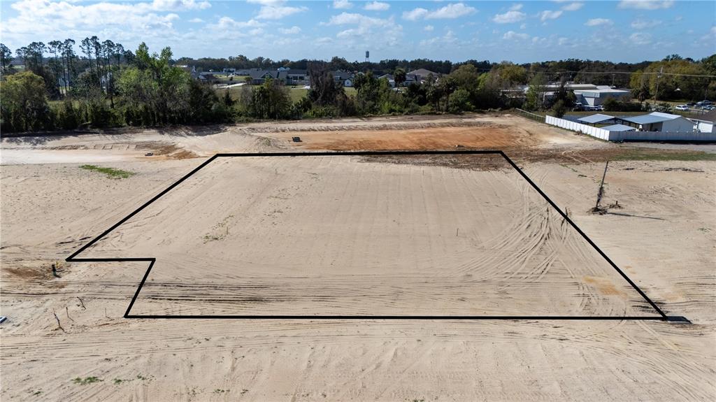 An aerial view shows a cleared, sandy rectangular lot outlined in black — 32814 DUNNE ROAD, SAN ANTONIO, FL