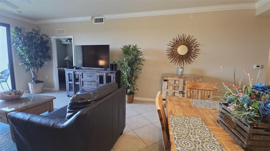 A living and dining area features tile floors, a dark leather sofa, and wooden furniture — 7005 RIVER HAMMOCK DRIVE UNIT 305, BRADENTON, FL