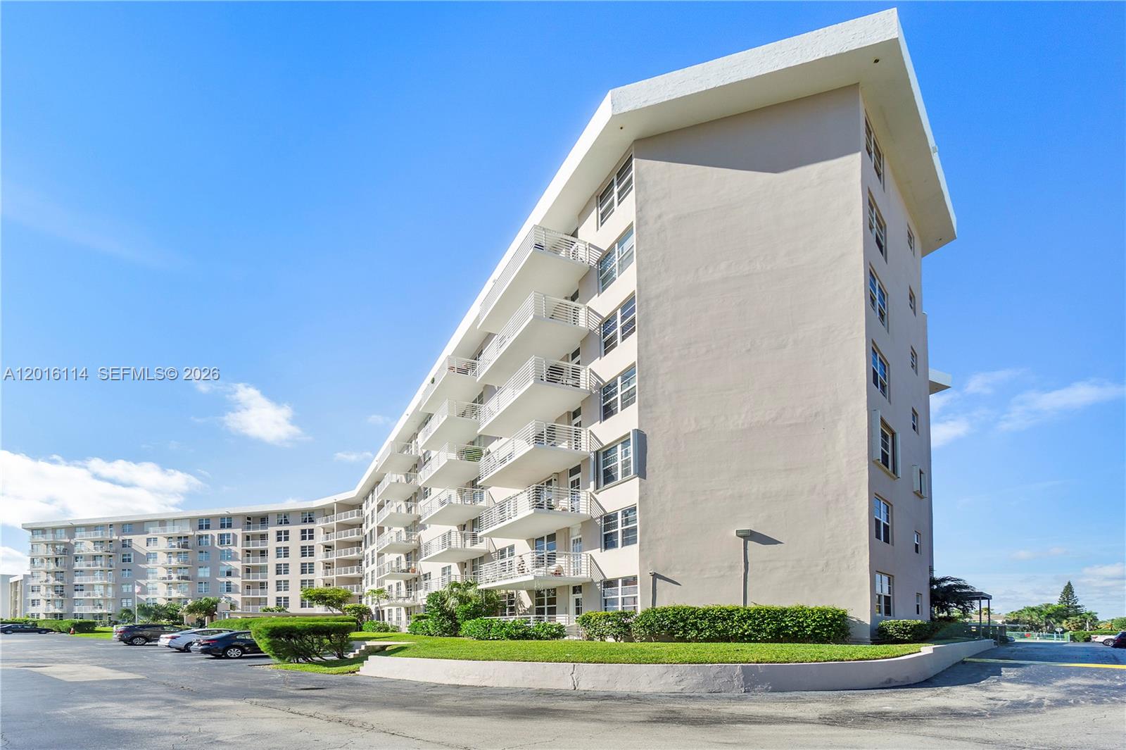 A multi-story apartment building with balconies and a parking lot under a clear blue sky — 2851 S Ocean Blvd # 7U, Boca Raton FL 33432, BOCA RATON, FL