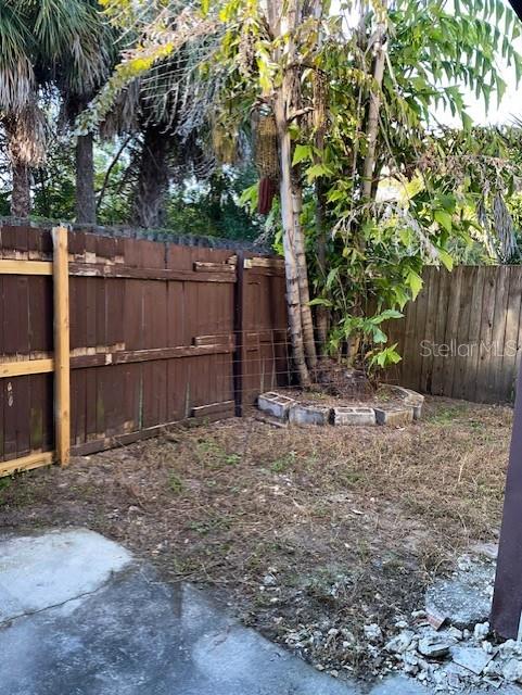A backyard area features a wooden fence, a palm tree, and a concrete patio — 3994 CRAYRICH CIRCLE UNIT C4, ORLANDO, FL