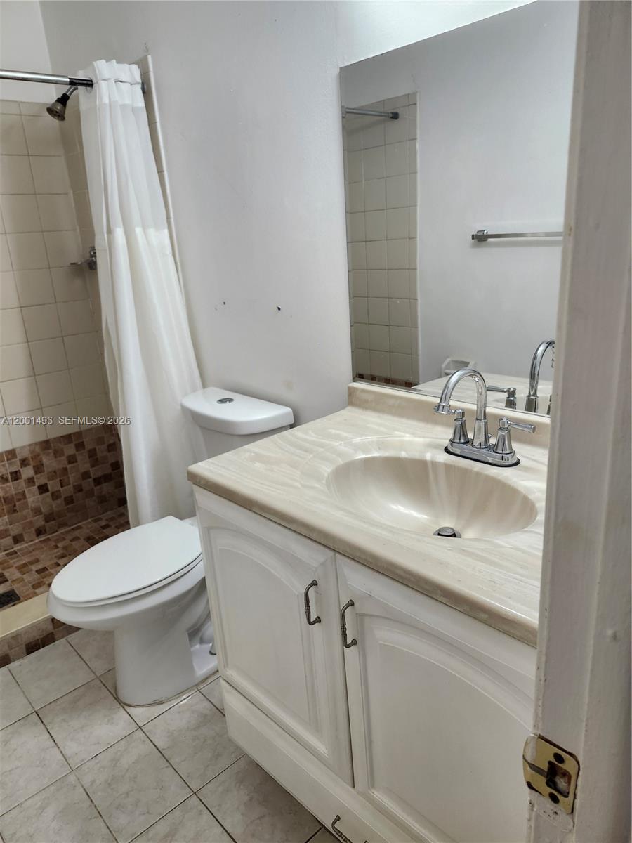 A bathroom features a white vanity, a toilet, and a shower with a curtain — 11219 SW 88th St # 205C, Miami FL 33176, MIAMI, FL