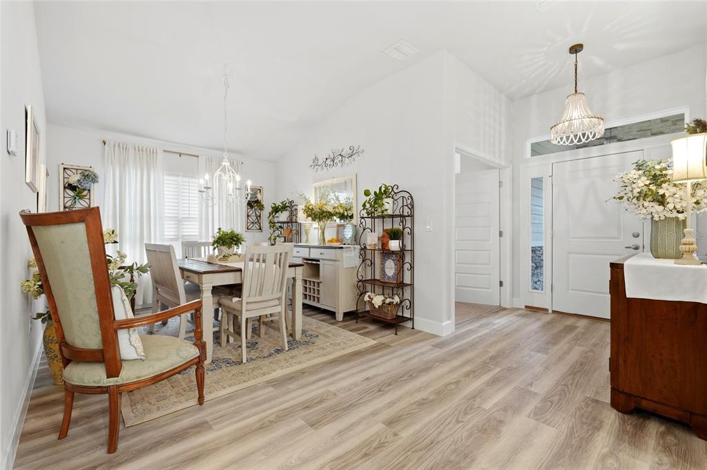 A dining area with wood-look flooring, a chandelier, and an entryway with a light fixture — 203 SW SILVER PALM DRIVE, LAKE CITY, FL