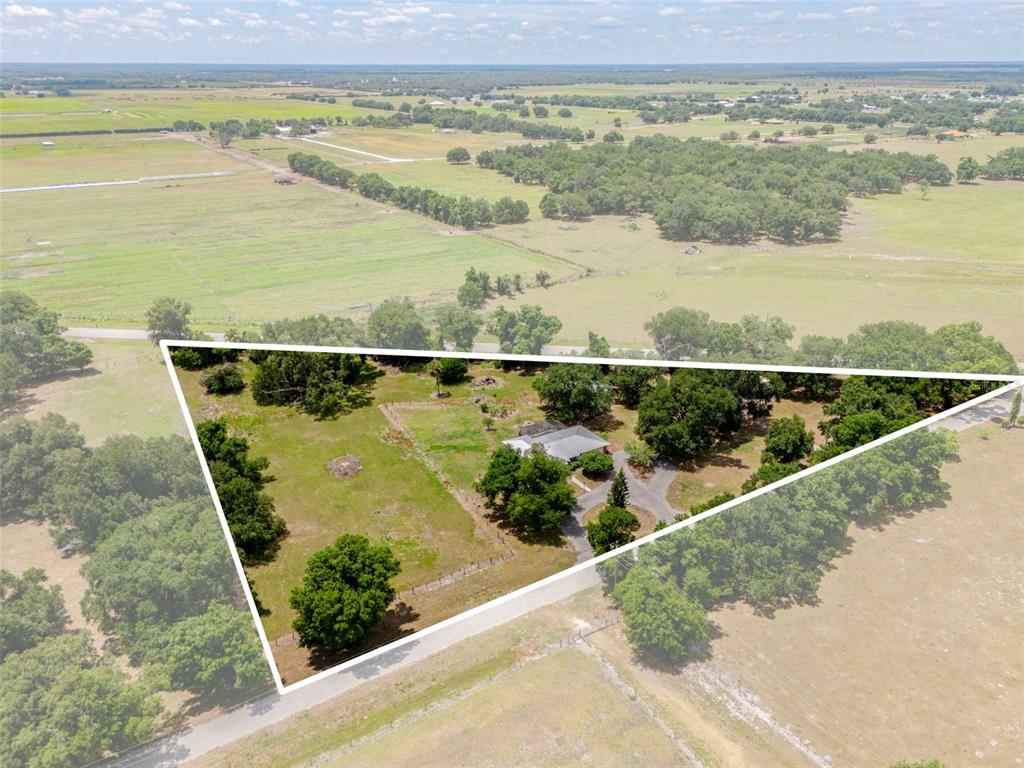 An aerial view shows a house on a triangular lot surrounded by rural fields — 2087 SW GARNER AVENUE, ARCADIA, FL