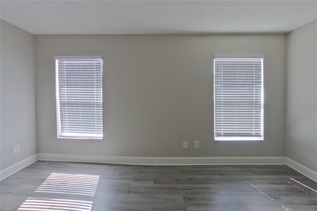 An open-concept living area with gray wood-look flooring, a ceiling fan, and a white kitchen — 162 HIDDEN POINTE LANE, GROVELAND, FL