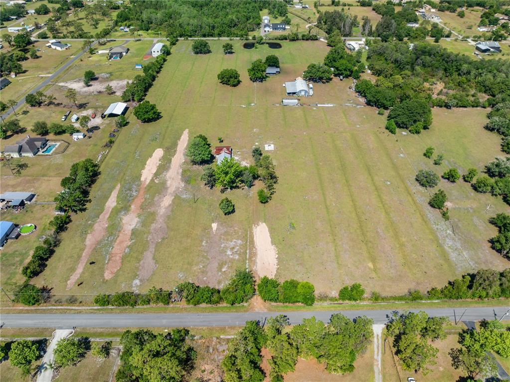 An aerial view shows a large, grassy rural property with several outbuildings and scattered trees — 0 LA SALLE AVENUE, ST CLOUD, FL