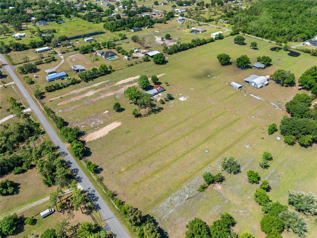 An aerial view shows a large, grassy rural lot with a house and several outbuildings — 0 LA SALLE AVENUE, ST CLOUD, FL