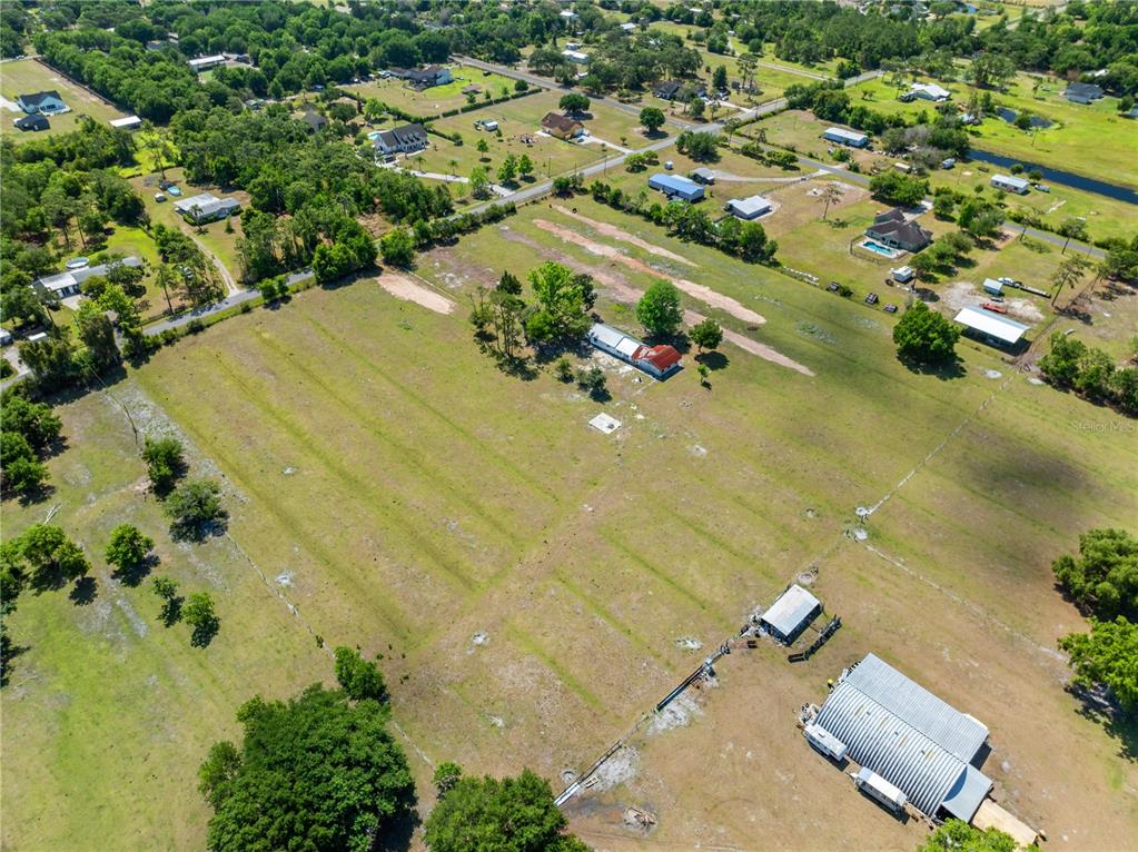 An aerial view shows a large, grassy rural property with a house and outbuildings — 0 LA SALLE AVENUE, ST CLOUD, FL