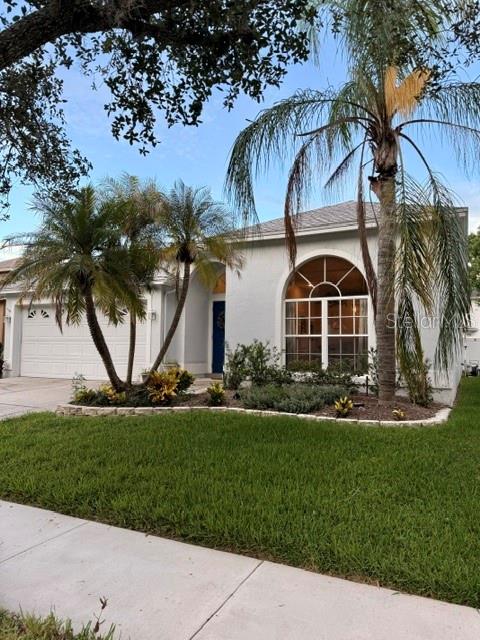 A single-story house with a white exterior, a two-car garage, and palm trees in front — 13620 WATERHOUSE WAY, ORLANDO, FL