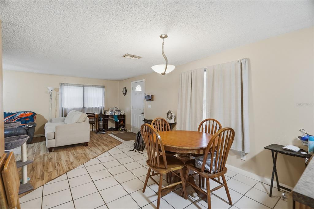 A dining area with a wooden table and chairs transitions into a living room space — 5818 CHERRY ROAD, LAKELAND, FL
