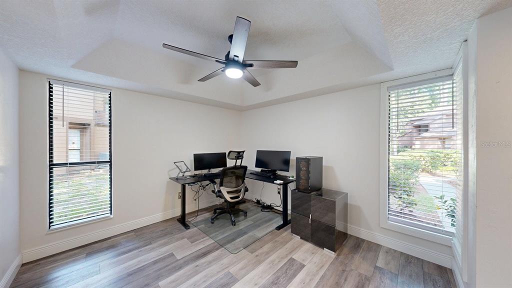 A home office features a corner desk, two windows with blinds, and wood-look flooring — 15 PINE HURST PLACE UNIT 15, PALM COAST, FL