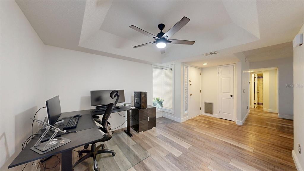 A home office with wood-look flooring, a ceiling fan, and a desk setup — 15 PINE HURST PLACE UNIT 15, PALM COAST, FL