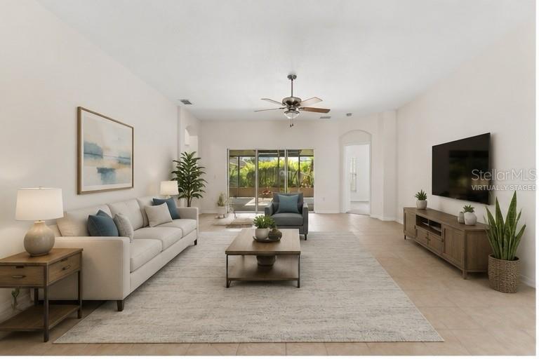 A living room features a beige sofa, wooden coffee table, media console, and sliding glass doors — 106 VISTA DRIVE, KISSIMMEE, FL
