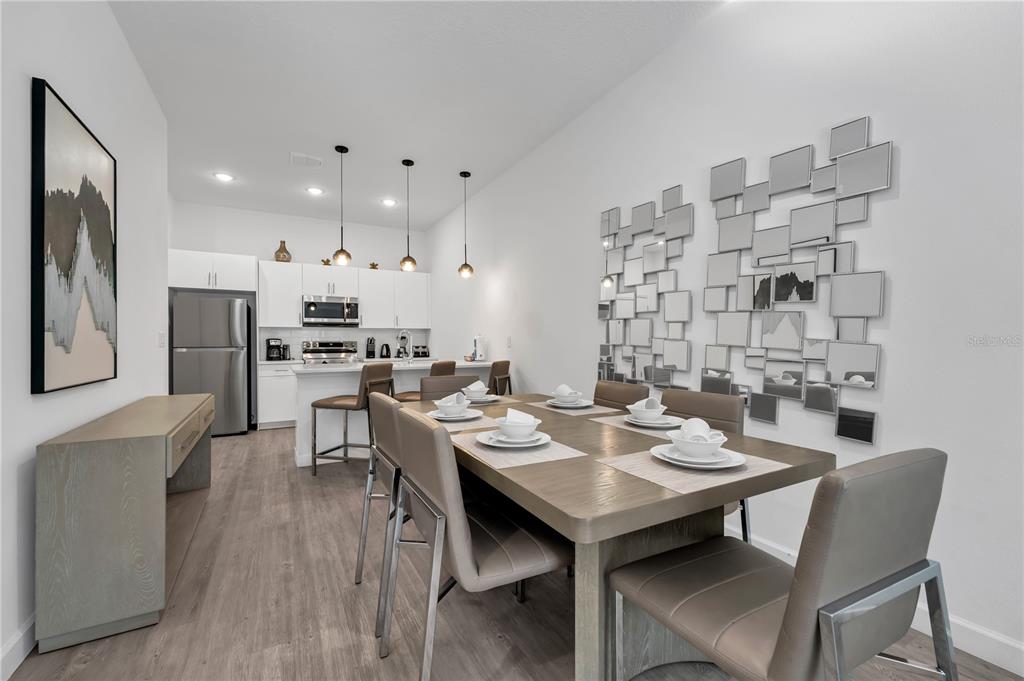 A dining area with a wooden table and chairs sits adjacent to a modern kitchen — 509 FAMAGUSTA DR., DAVENPORT, FL