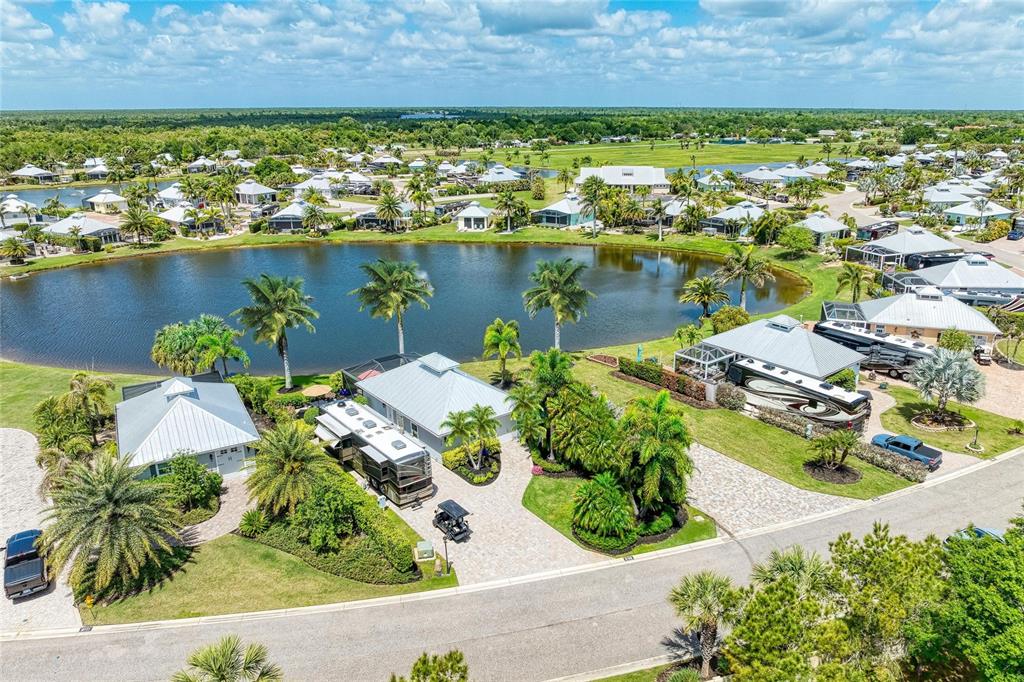 An aerial view shows waterfront homes with RV ports and palm trees around a lake — 8789 SW SAND CRANE CIRCLE LOT 38, ARCADIA, FL