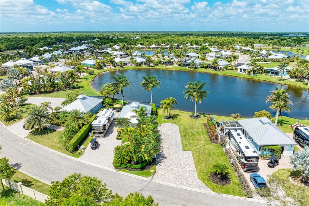 An aerial view shows two adjacent properties with RVs parked on paved lots near a lake — 8789 SW SAND CRANE CIRCLE LOT 38, ARCADIA, FL