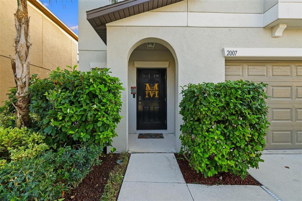 The exterior view shows a house entrance with a black door, bushes, and a garage — 2007 SEA SALT COURT, RUSKIN, FL