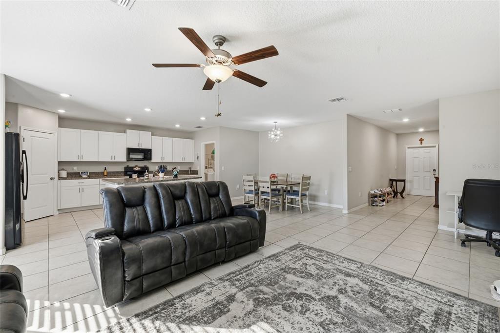 An open-concept living room and kitchen area with tile flooring and a ceiling fan — 2007 SEA SALT COURT, RUSKIN, FL