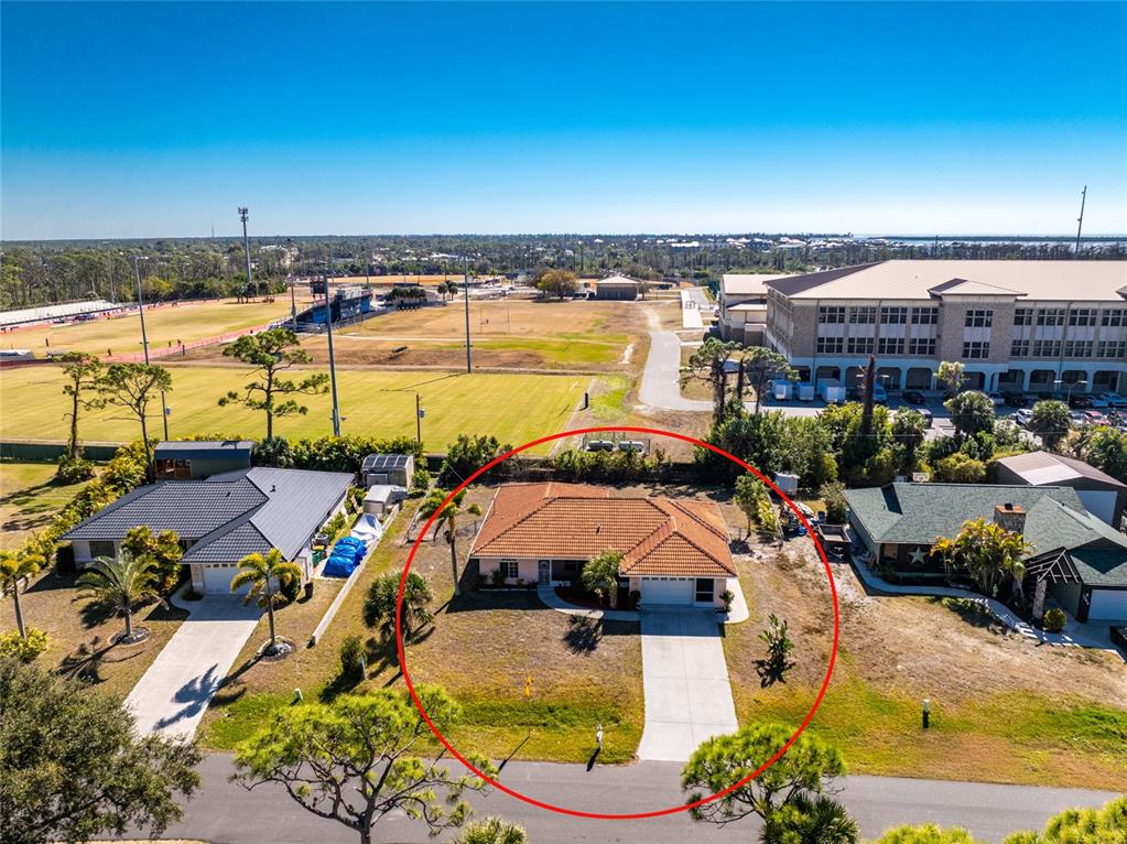 An aerial view shows a single-story house with a tiled roof and a concrete driveway — 1053 BAY HARBOR DRIVE, ENGLEWOOD, FL