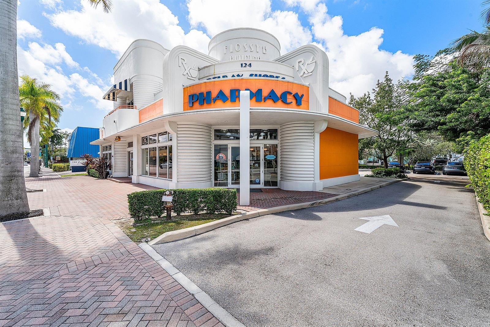 An exterior view of a corner pharmacy building with Art Deco architectural details and signage — 124 NE 5th Avenue, Delray Beach FL 33483, DELRAY BEACH, FL